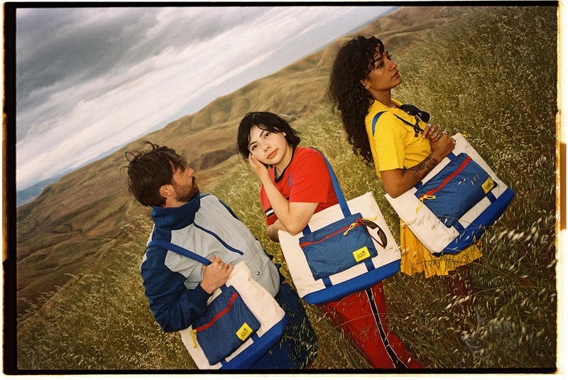 Cool people wearing Long Weekend retro bags at sunset.