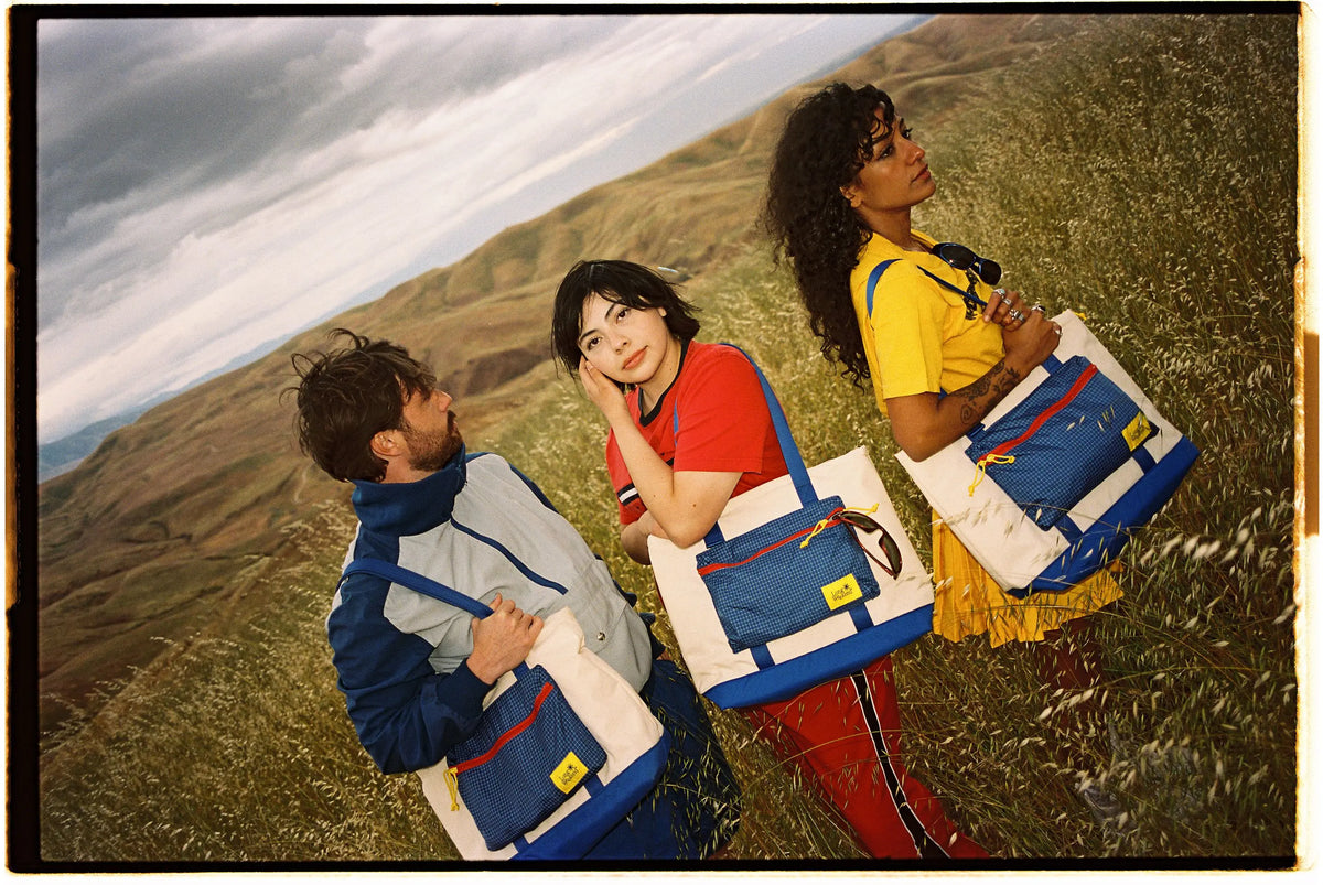 Cool people wearing Long Weekend retro bags at sunset.