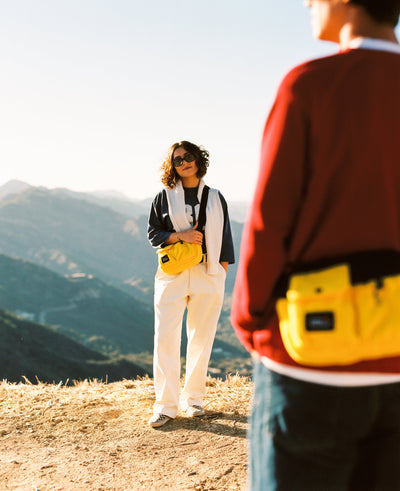 Man in red and woman in white wearing yellow fleece shoulder bags